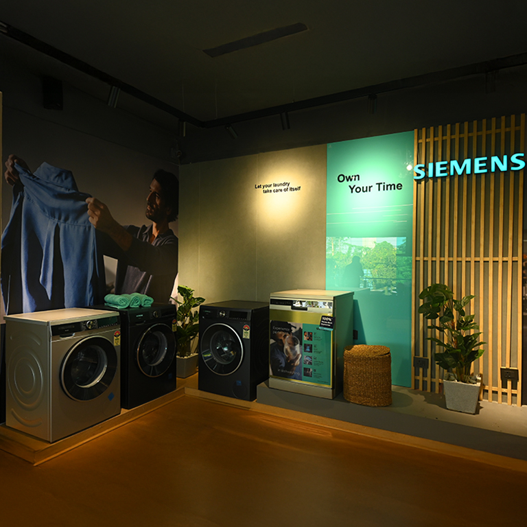 Interior of a premium kitchen and appliance showroom with a lounge area.